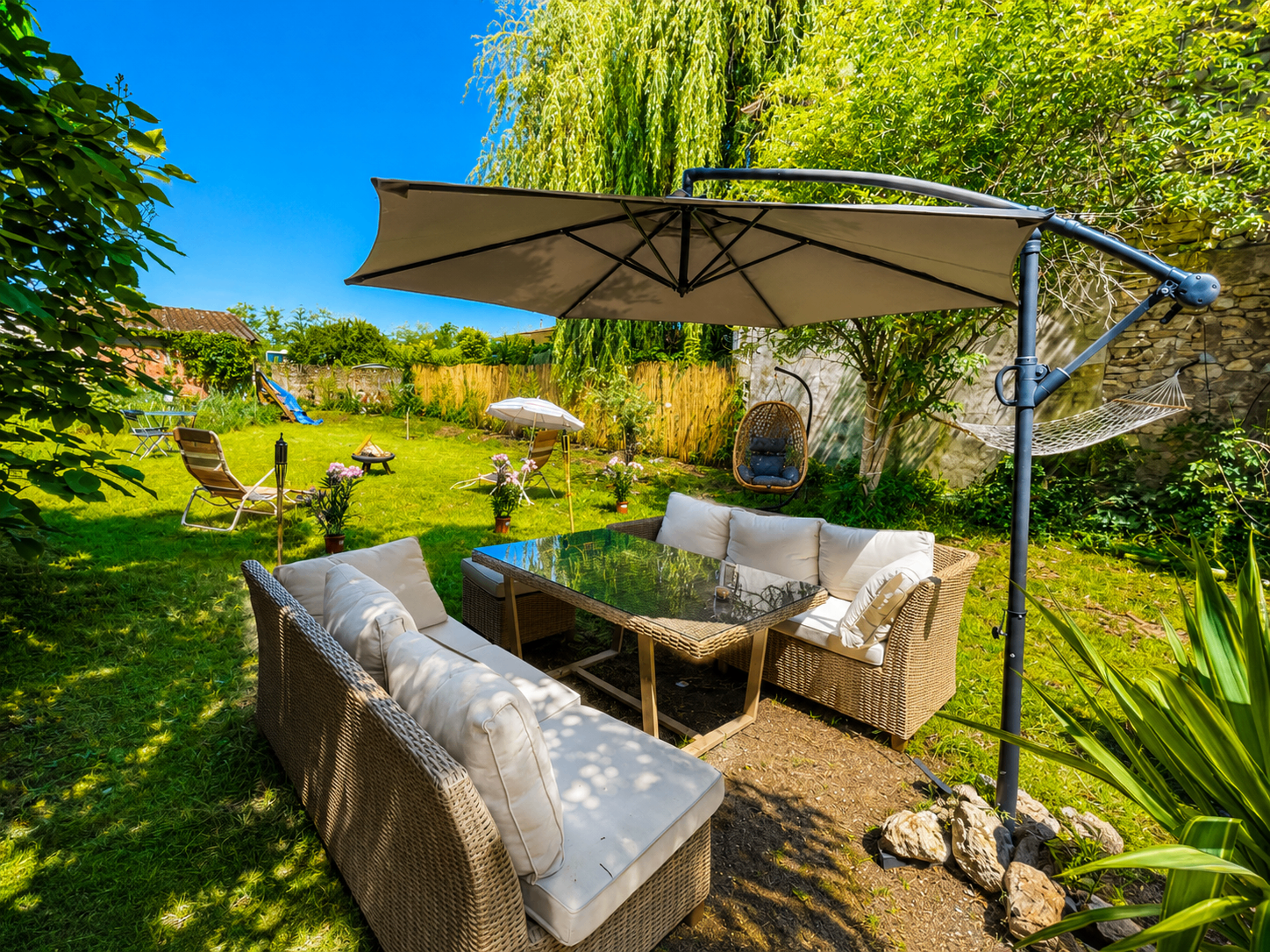 Jardin avec longue table dressée et brasero au crépuscule
